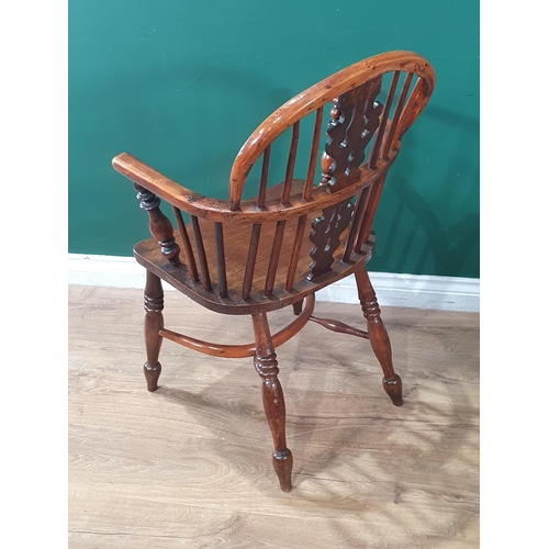 566 - A 19th Century ash and yew Windsor Elbow Chair with pierced splat back raised on turned supports uni... 