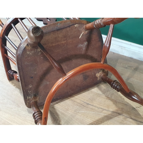 566 - A 19th Century ash and yew Windsor Elbow Chair with pierced splat back raised on turned supports uni... 