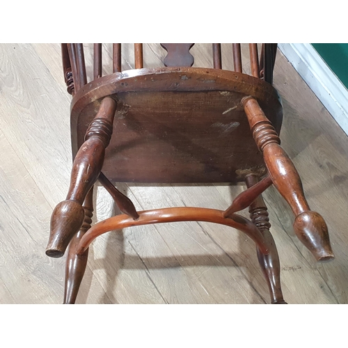 566 - A 19th Century ash and yew Windsor Elbow Chair with pierced splat back raised on turned supports uni... 