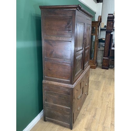 579 - An 18th Century oak Bacon Cupboard with pair of panelled doors enclosing wooden hooks, above three d... 