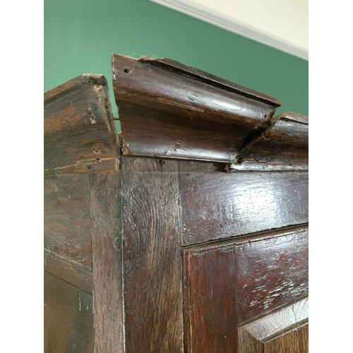 579 - An 18th Century oak Bacon Cupboard with pair of panelled doors enclosing wooden hooks, above three d... 