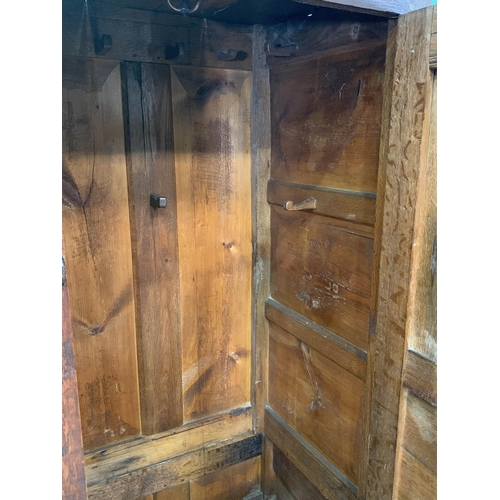 579 - An 18th Century oak Bacon Cupboard with pair of panelled doors enclosing wooden hooks, above three d... 