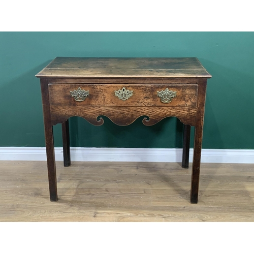 581 - An 18th Century oak Side Table fitted frieze drawer above a scroll shaped frieze and raised on chamf... 