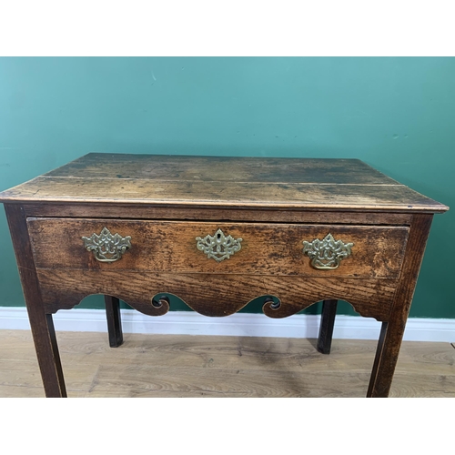 581 - An 18th Century oak Side Table fitted frieze drawer above a scroll shaped frieze and raised on chamf... 