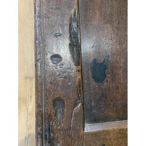 605 - A 17th Century oak Coffer with hinged panelled top and panelled front, 4ft 1in W x 1ft 9in H