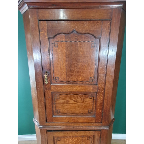 606 - An antique oak double Corner Cupboard, the upper door with cupid's bow and chequered strung panelled... 