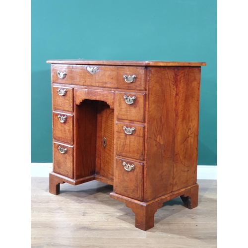 612 - A George III walnut Kneehole Desk with feather banded and quarter-veneered hinged top opening to rev... 