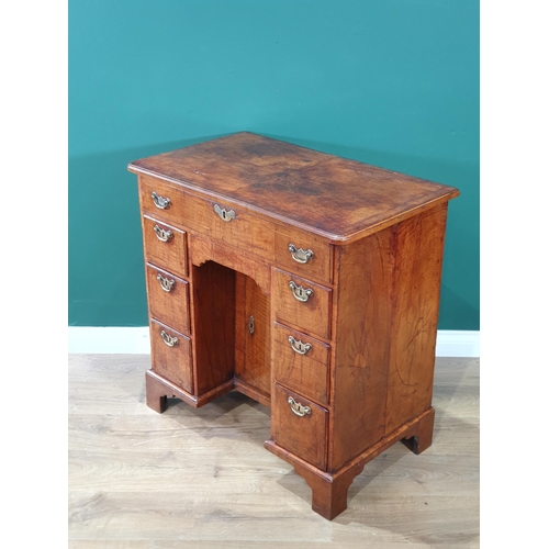 612 - A George III walnut Kneehole Desk with feather banded and quarter-veneered hinged top opening to rev... 