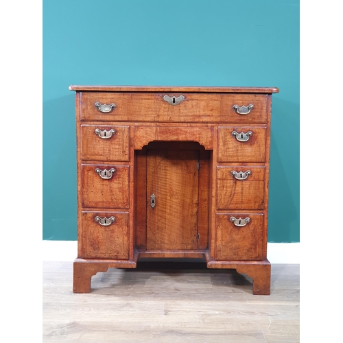 612 - A George III walnut Kneehole Desk with feather banded and quarter-veneered hinged top opening to rev... 