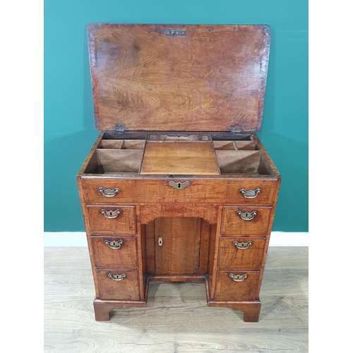 612 - A George III walnut Kneehole Desk with feather banded and quarter-veneered hinged top opening to rev... 