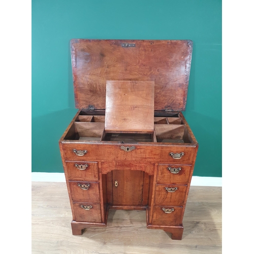 612 - A George III walnut Kneehole Desk with feather banded and quarter-veneered hinged top opening to rev... 