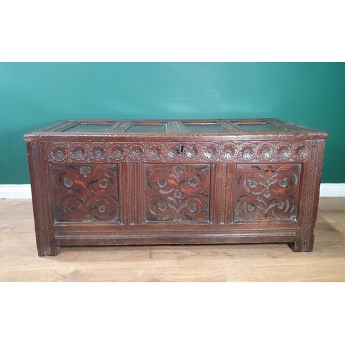 615 - An 18th Century oak Coffer with panelled hinged top, flower head carved frieze above inlaid panels, ... 