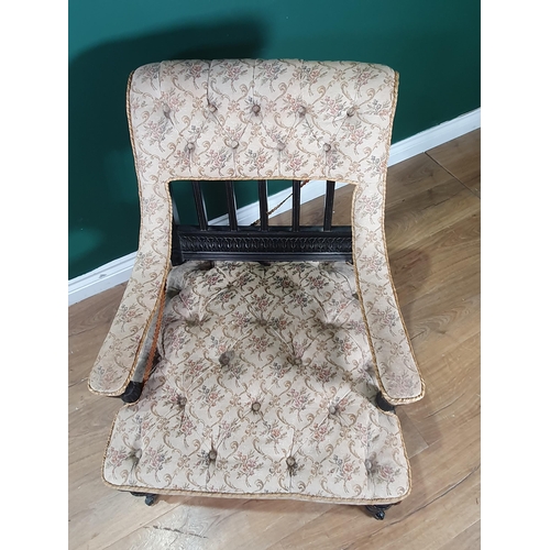 620 - A 19th Century ebonised and upholstered low Armchair with carved detail and raised on turned taperin... 