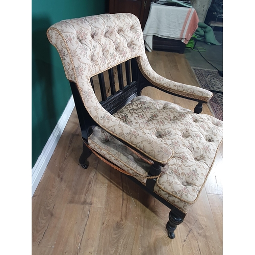 620 - A 19th Century ebonised and upholstered low Armchair with carved detail and raised on turned taperin... 