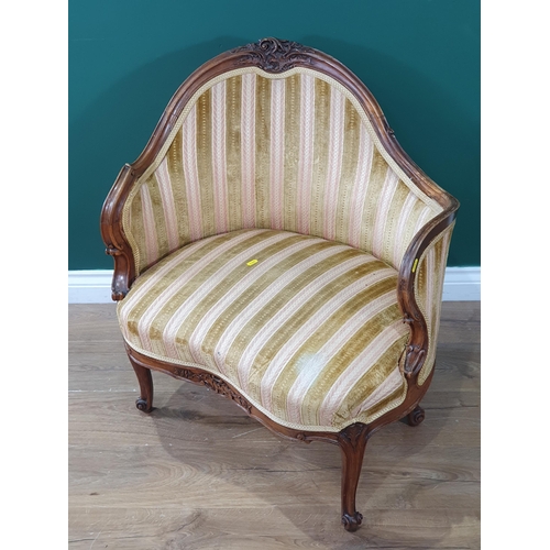 624 - A French style carved walnut Occasional Chair with shaped upholstered back and seat and raised on sl... 