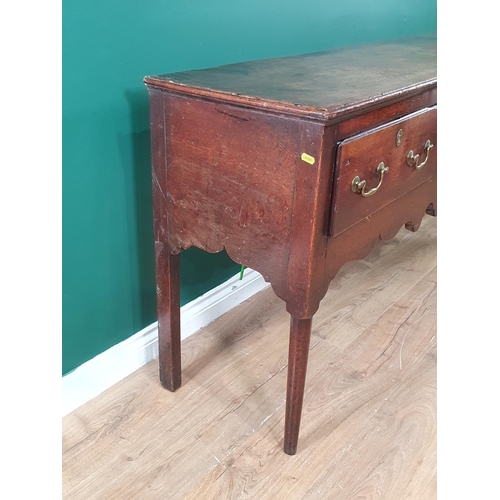 625 - An 18th Century oak Dresser Base fitted three frieze drawers above a shaped frieze, raised on turned... 