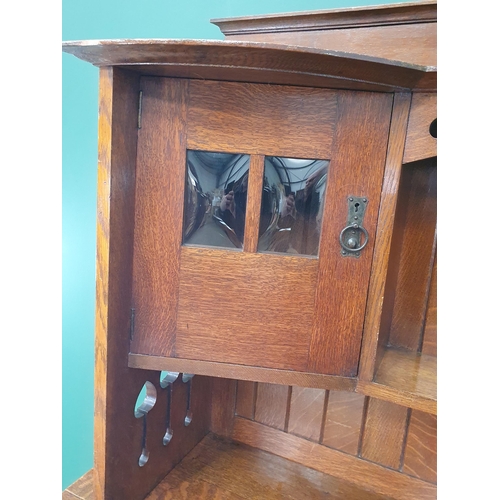 628 - An Arts and Crafts oak Dresser, the upper section fitted a pair of glazed door, the lower section fi... 