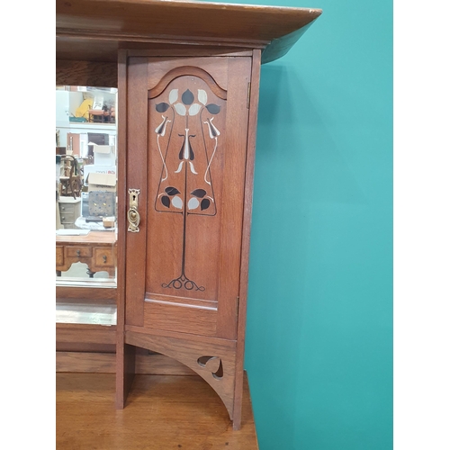 629 - An oak Art Nouveau Mirrorback Sideboard, the upper section with a pair of inlaid doors, the base fit... 