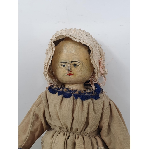 645 - An antique folk art Peg Doll with painted facial features, hands and legs in traditional rustic cost... 