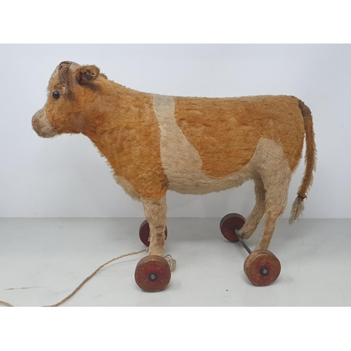 648 - A vintage Steiff pull along Cow with button in ear (some wear to horns and tail) 10in H, and a pull ... 