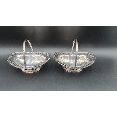 7 - A pair of Victorian silver pierced oval Sweetmeat Baskets with swing handles on pedestal bases, Shef... 