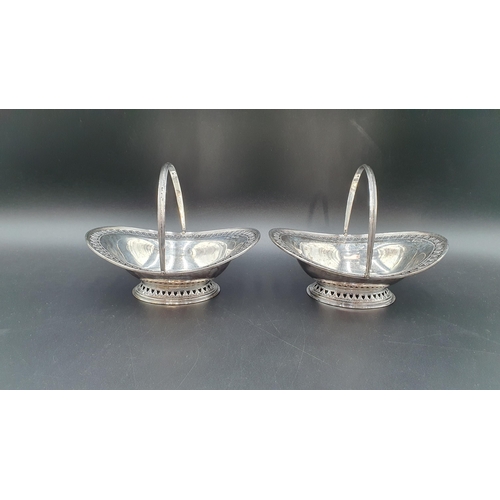 7 - A pair of Victorian silver pierced oval Sweetmeat Baskets with swing handles on pedestal bases, Shef... 