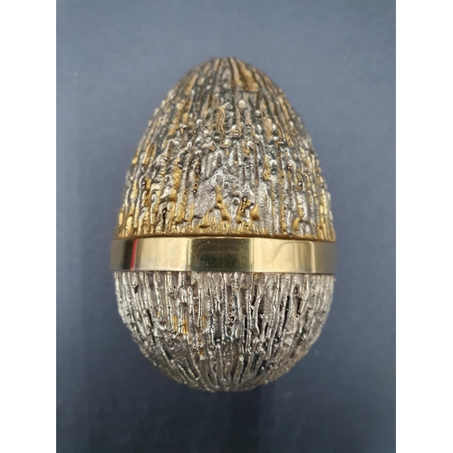 86 - A Stuart Devlin silver-gilt limited edition Egg with bark effect textured finish enclosing a mouse a... 