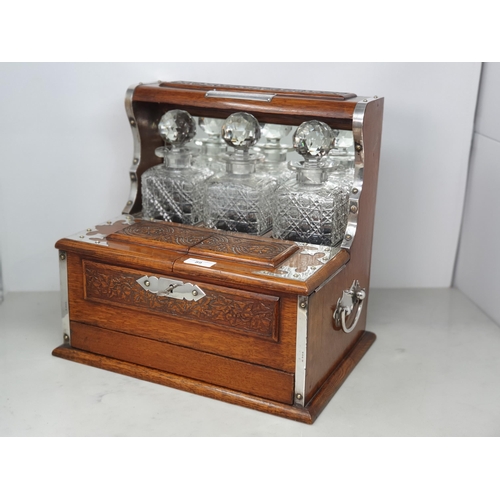 89 - A George V silver mounted oak Tantalus/Games Compendium with presentation inscription 