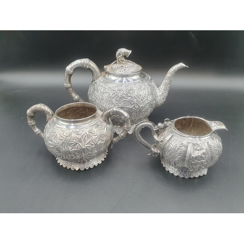 90 - A Chinese silver three piece Tea Service of globular form, the teapot and sugar bowl with all over b... 