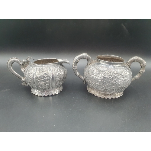 90 - A Chinese silver three piece Tea Service of globular form, the teapot and sugar bowl with all over b... 