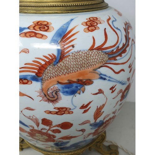 404 - A Chinese porcelain and gilt metal Table Lamp with design of dragons and flowers and raised on four ... 