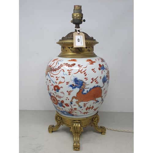 404 - A Chinese porcelain and gilt metal Table Lamp with design of dragons and flowers and raised on four ... 