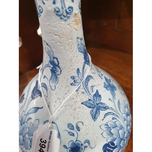 394 - A blue and white Delft Bottle Shaped Vase with all over Floral designs (Rim Chipped) 9.5