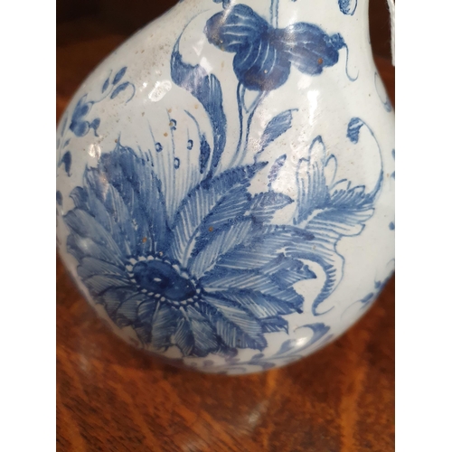 394 - A blue and white Delft Bottle Shaped Vase with all over Floral designs (Rim Chipped) 9.5