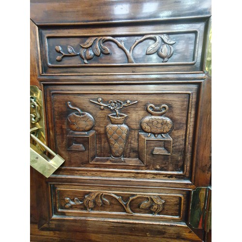 502 - A Chinese hardwood Cabinet on stand, the pair of cupboard doors carved vases and flowering branches,... 