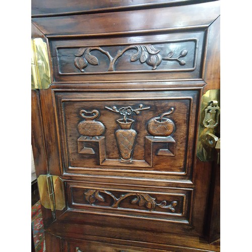 502 - A Chinese hardwood Cabinet on stand, the pair of cupboard doors carved vases and flowering branches,... 