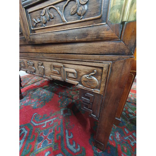 502 - A Chinese hardwood Cabinet on stand, the pair of cupboard doors carved vases and flowering branches,... 