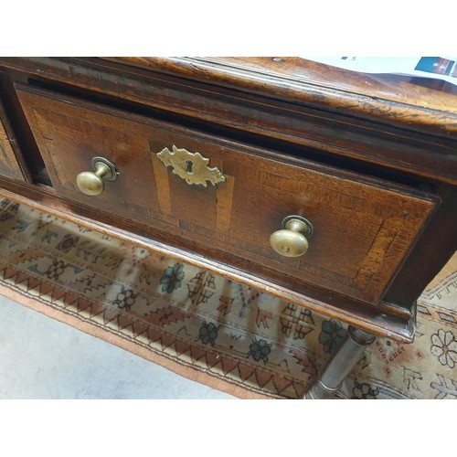 528 - An 18th Century oak Dresser Base with raised back, fitted four crossbanded frieze drawers on turned ... 