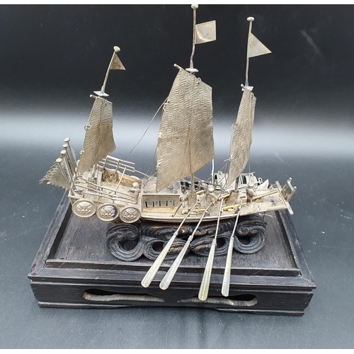 143 - A Chinese silver three masted Sailing Boat with figures and oars, and two smaller vessels, all under... 