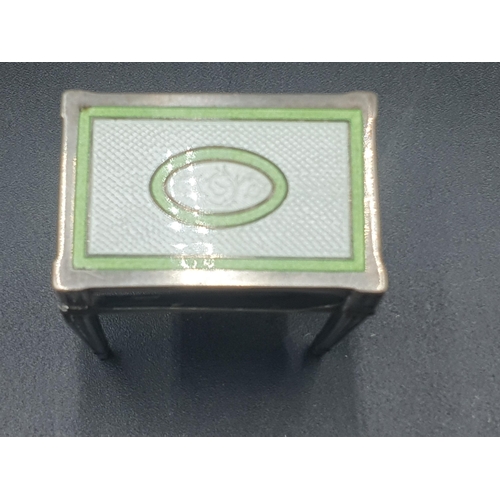 145 - A silver and green and white enamel Matchbox Holder in the form of a table, A/F