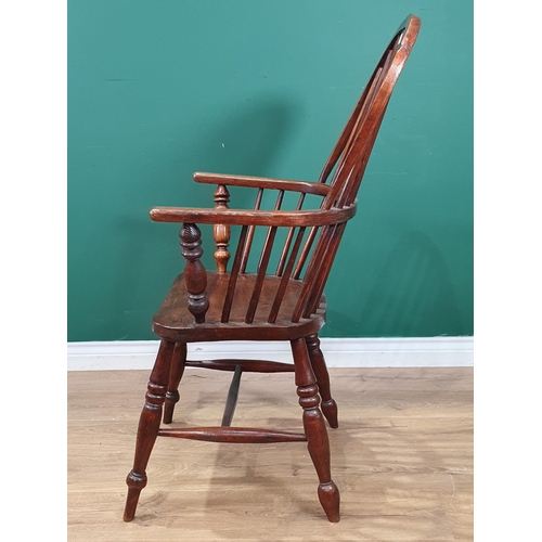 35 - An ash and elm Windsor Elbow Chair with pierced shaped splat, raised on turned supports and H stretc... 