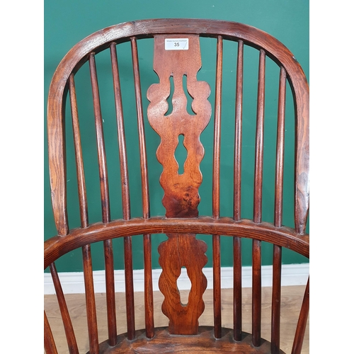 35 - An ash and elm Windsor Elbow Chair with pierced shaped splat, raised on turned supports and H stretc... 