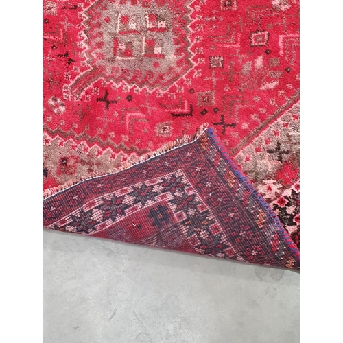 38 - A red ground woollen Rug with large central lozenge within cream and red multiple borders 6ft 4in L ... 