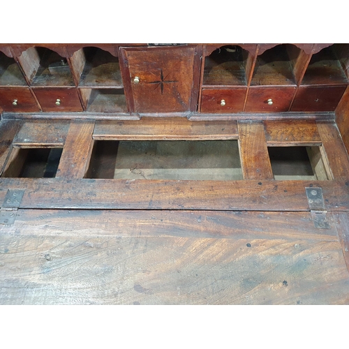 43 - An 18th Century elm Bureau, the interior fitted pigeon holes and drawers (one drawer missing) either... 