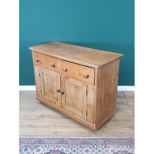 482 - A large Pine two door cupboard fitted two drawers, raised on bun feet 3ft 3