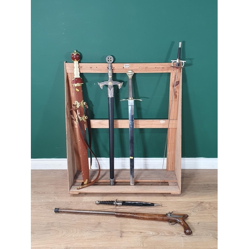 488 - A collection of various swords some in scabbards a dagger and a model of a rifle (stand not included... 