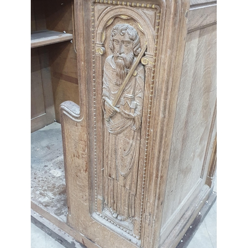 493 - A carved oak Church Pew & Lectern with pink seat cushion with two carved apostles with gilt highligh... 