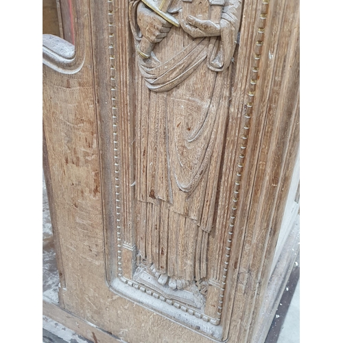 493 - A carved oak Church Pew & Lectern with pink seat cushion with two carved apostles with gilt highligh... 