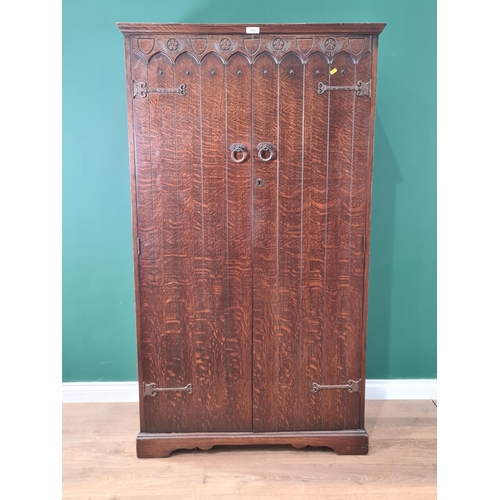 519 - An oak two door Wardrobe with arcaded design, strap hinges and fitted interior 5ft 6in H x 3ft 2in W... 