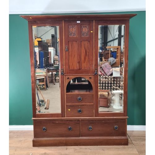 521 - An Art Nouveau style mahogany Wardrobe the central door with carved stylised tree panels, above open... 